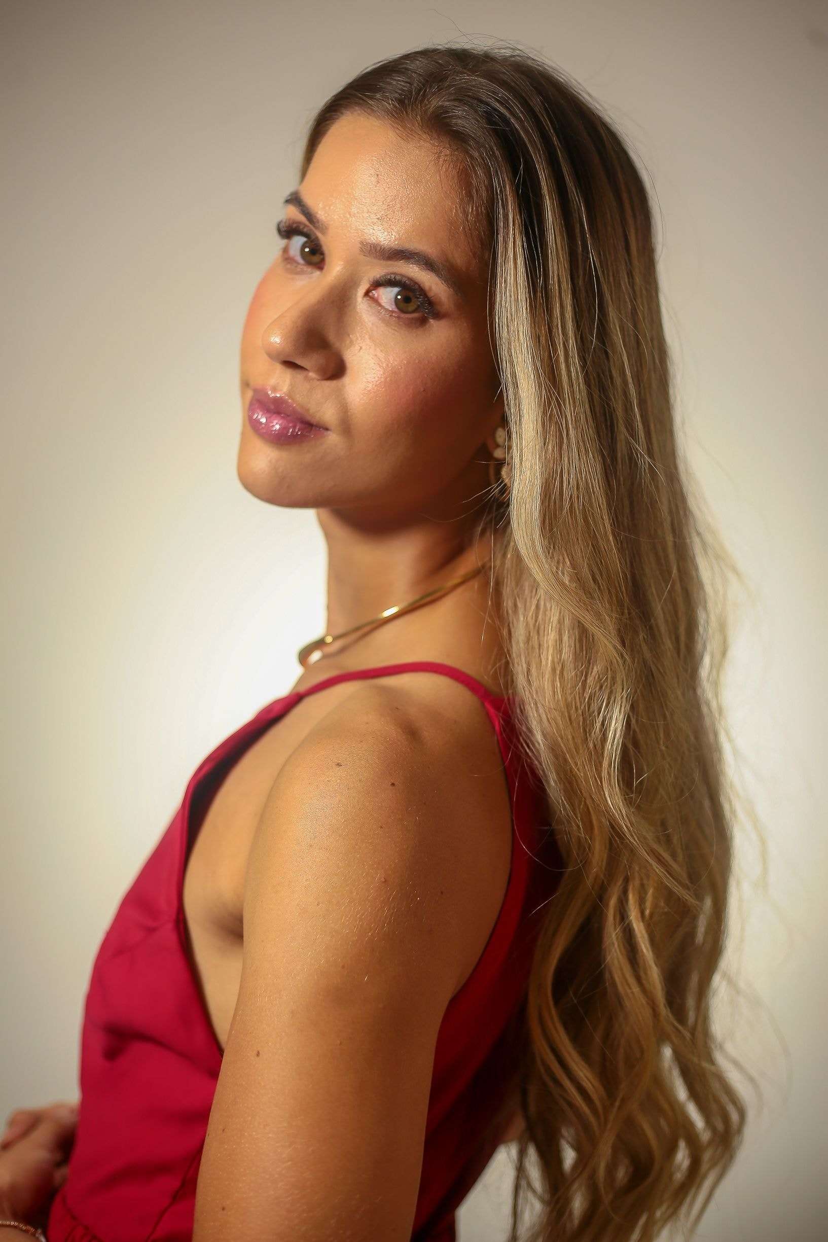 Dra. Alice Fortes de perfil, de vestido vermelho.